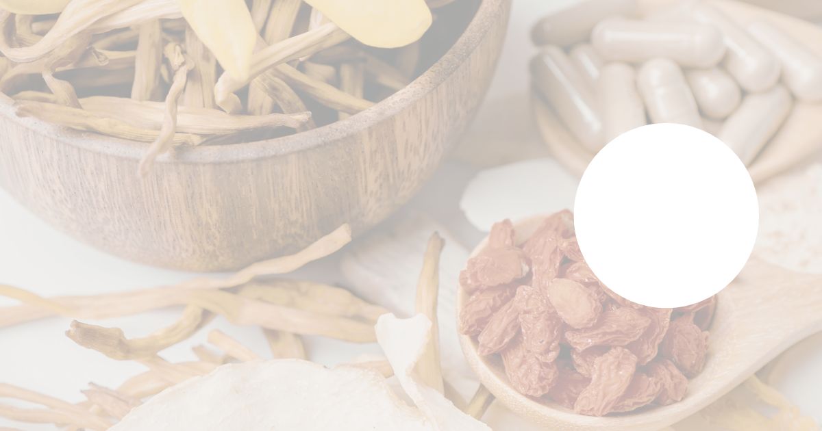 Soft focus background of herbal ingredients and capsules with a blank circular space for a logo or design element.