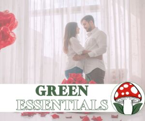 A couple in white clothing embraces in a softly lit room with sheer curtains, surrounded by red roses and heart-shaped balloons. The text ‘GREEN ESSENTIALS’ appears at the bottom alongside a red-and-white mushroom logo, creating a romantic, wellness-themed design.